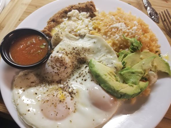 Huevos Rancheros Breakfast plated with Mexican rice and Salsa