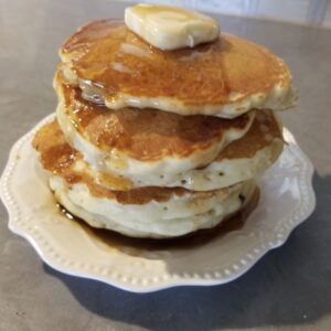 Heart Healthy Buttermilk Pancakes in a stack of four with butter and syrup.