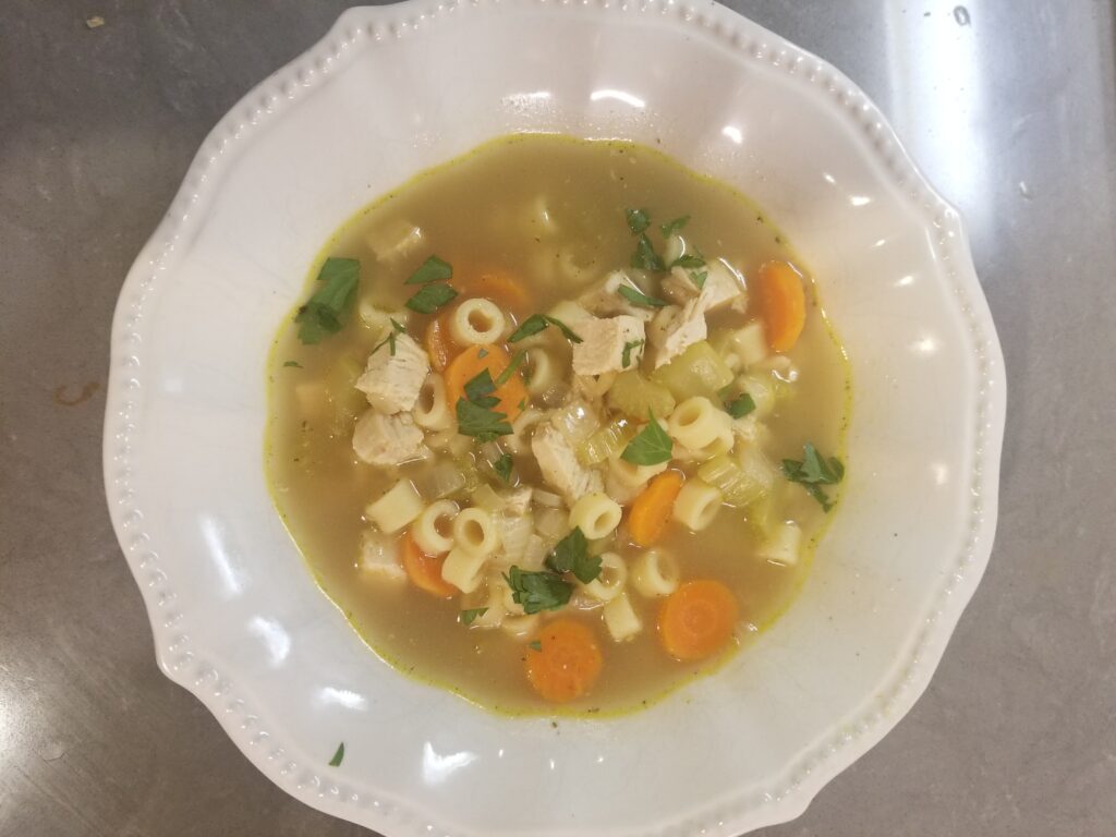 Mom's Chicken Noodle Soup made with Ditallini pasta served in a white bowl.