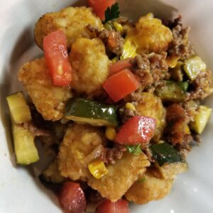 Skillet Beef, Corn & Zucchini Tater Tot Casserole served in a white bowl.